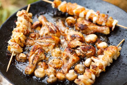 Chicken meat and champignons on barbecue, selective focus
