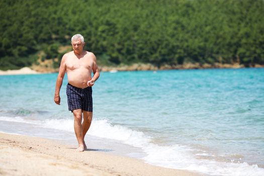Senior man walking on the beach