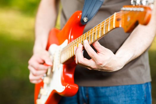 Man playing guitar/ selective focus on the left hand