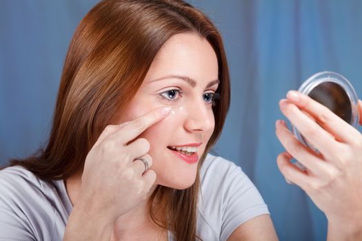 Young woman applied anti-wrinkle cream