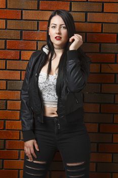 hot twenty year old woman against a brick wall