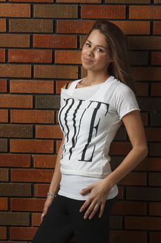 twenty something girl against a brick wall