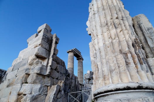 View of Didyma Ancient City in Aydın, Turkey, with granit columns and temple, on blue sky background.