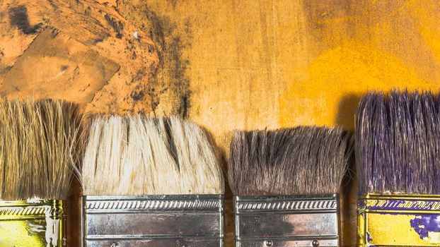 Oil paint brushes on wood painted background .