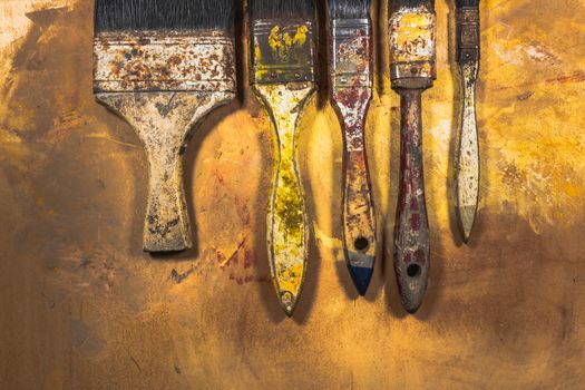 Oil paint brushes on wood painted background .