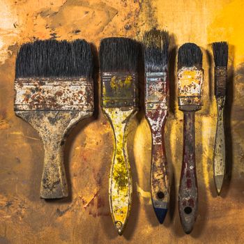 Oil paint brushes on wood painted background .