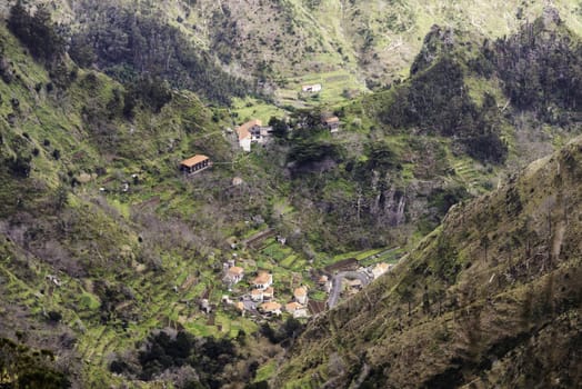 mountains and nature of Madeira island near Rabacal with houses and hairpin bend roads