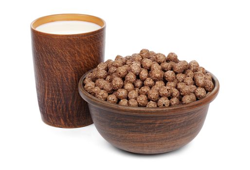 Chocolate cereal balls in a ceramic bowl and a mug with milk isolated on white background.