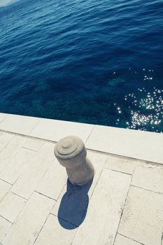 stone bollard on boat dock and sea