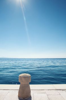 stone bollard on boat dock and blue sea