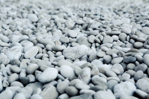 Naturally polished white rock pebbles background on beach