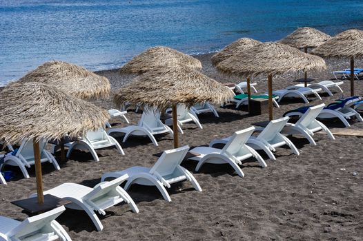 Cane umbrellas at Black Beach near Kamari, Santorini Greece