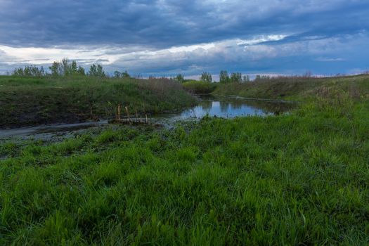 The photograph shows an evening river landscape