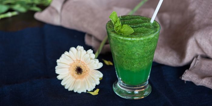 Healthy organic green smoothie with basil mint and lemon