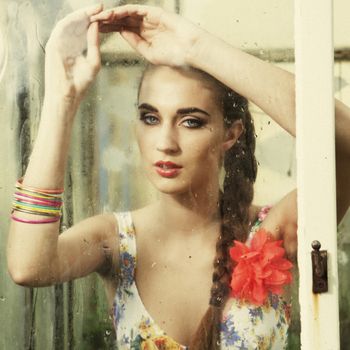 sorrow colorful girl behind wet window