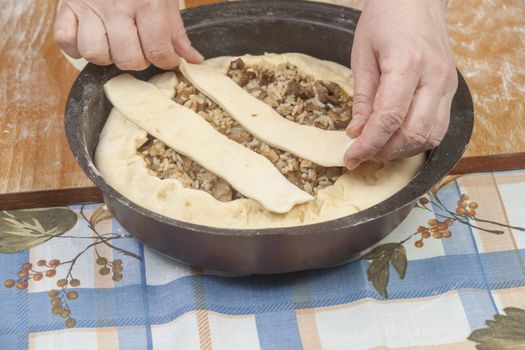 Making pie. Raw dough with filling in black metal baking form