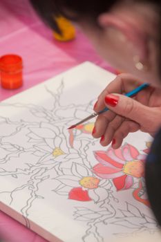 A woman hand with pencil is drawing picture with flowers