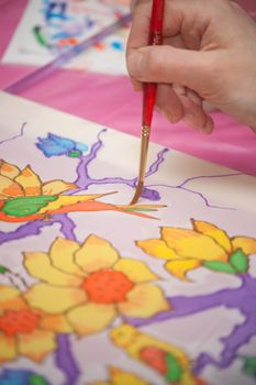 A woman hand with pencil is drawing picture with flowers