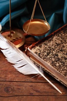 Vintage still life with quill near old book and weight scale