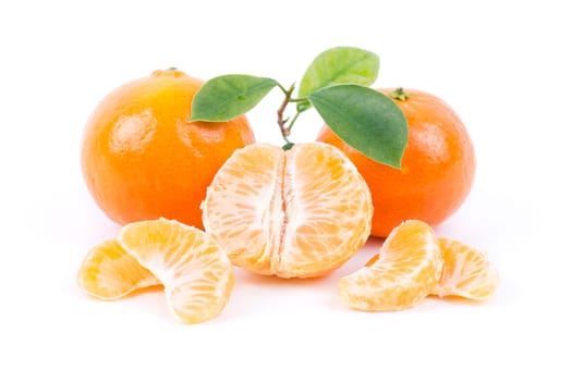 Tangerines with leaves and slices on white background