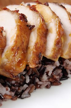 Cut into slices roasted chicken breast on a diverse boiled rice