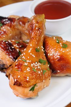 Fried chicken leg with sesame seeds in a plate and sauce