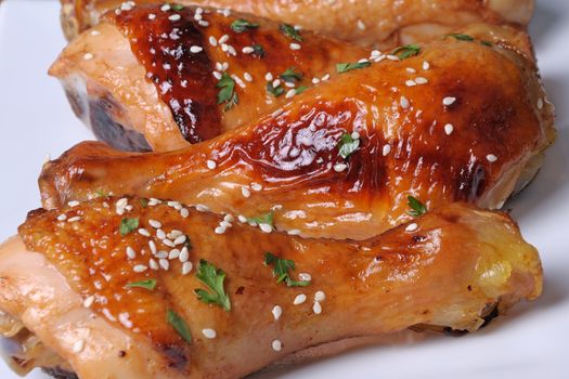 Fried chicken leg with sesame seeds in a plate closeup