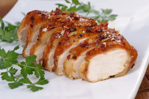 baked chicken breast sliced on a plate close-up