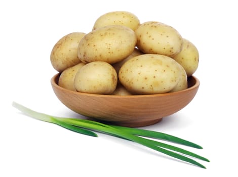 Raw unpeeled potatoes in a wooden bowl and green onions, isolated on white background.