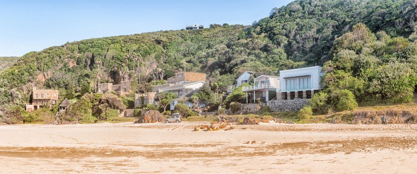 KNYSNA, SOUTH AFRICA - MARCH 5, 2016: Early morning view of houses on the slope of a hill at the beach in Noetsie, some built to look like castles