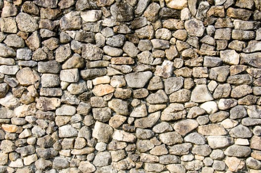 Stone background, uneven cracked real stone wall surface with cement.