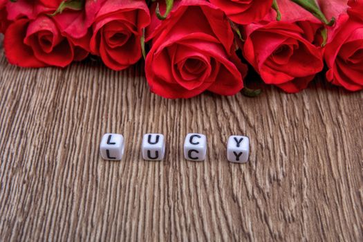 White cubes as a inscription Lucy on a wooden background