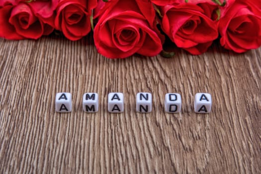 White cubes as a inscription Amanda on a wooden background