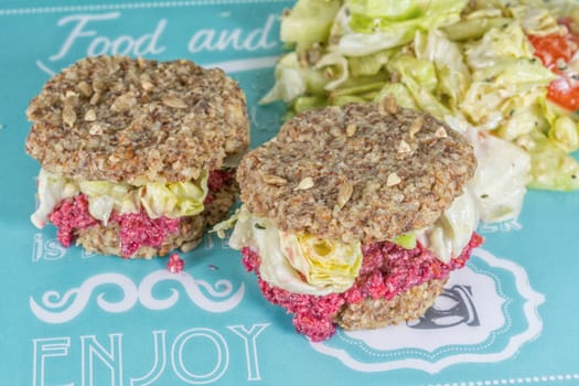 Raw burgers with beetroot and salad on a blue background