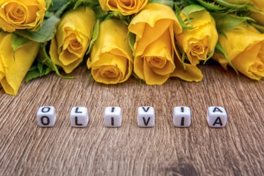 White cubes as a inscription Olivia on a wooden background