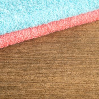 The blue and pink towel on wooden plank background.