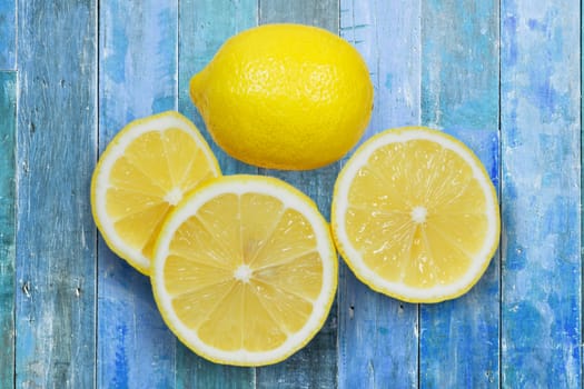 Sliced lemons isolated on blue wood background.