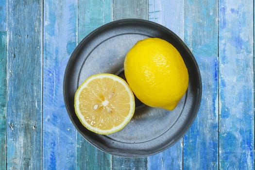 Sliced lemons isolated on blue wood background.