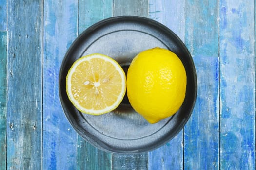 Sliced lemons isolated on blue wood background.