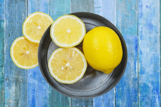 Sliced lemons isolated on blue wood background.