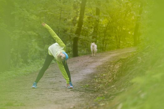 Sporty young female working out in forest.  Female runner during outdoor workout in nature. Fitness model outdoors. Weight Loss. Healthy lifestyle. 