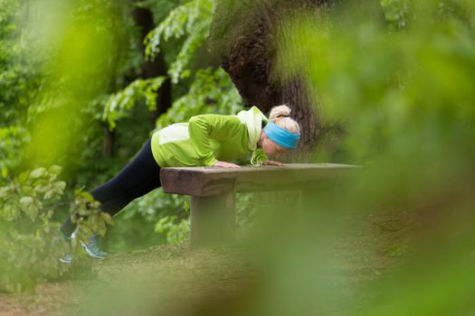 Sporty young female working out in forest.  Female runner during outdoor workout in nature. Fitness model outdoors. Weight Loss. Healthy lifestyle. 