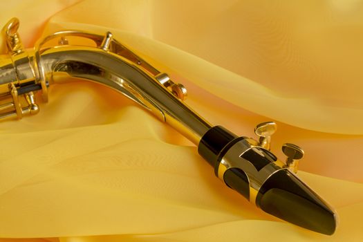 beautiful golden saxophone on delicate Yellow silk background