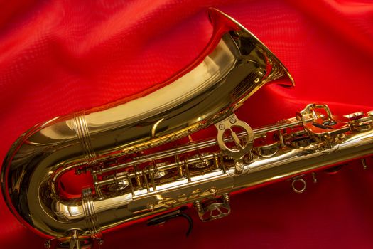 beautiful golden saxophone on delicate red silk background