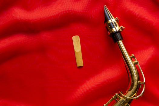 wooden Reeds and saxophone mouthpiece on a red background