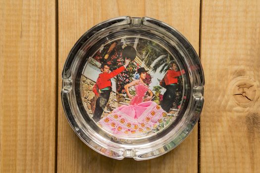 picture of Spanish dance in a glass ashtray on wooden background