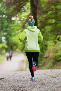 Sporty young female runner in forest.  Running woman. Female runner during outdoor workout in nature. Fitness model outdoors. Weight Loss. Healthy lifestyle. 