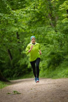 Sporty young female runner in forest.  Running woman. Female runner during outdoor workout in nature. Fitness model outdoors. Weight Loss. Healthy lifestyle. 