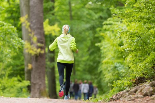 Sporty young female runner in forest.  Running woman. Female runner during outdoor workout in nature. Fitness model outdoors. Weight Loss. Healthy lifestyle. 