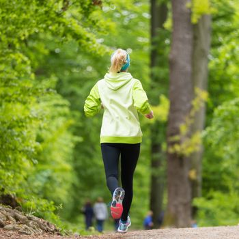 Sporty young female runner in forest.  Running woman. Female runner during outdoor workout in nature. Fitness model outdoors. Weight Loss. Healthy lifestyle. 